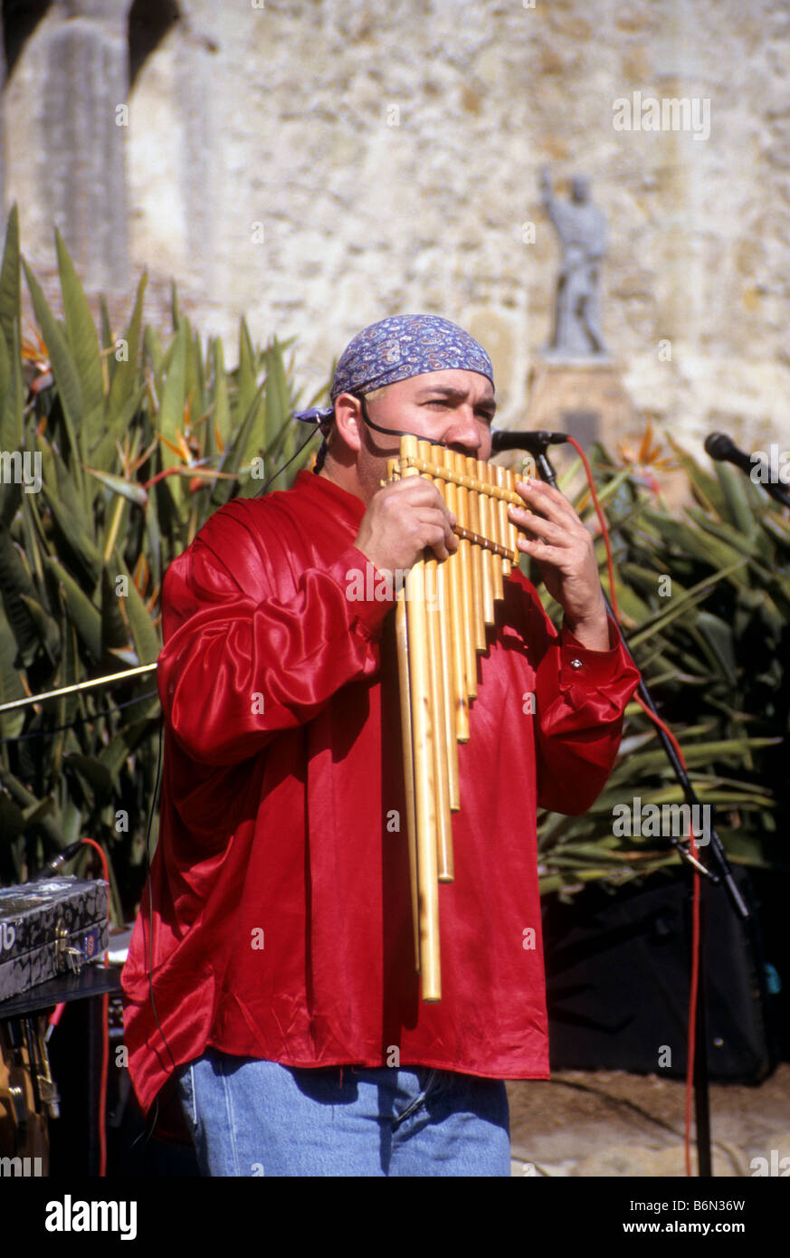 L'homme en costume traditionnel joue flûte de pan à la mission de San Juan Capistrano, Californie Banque D'Images