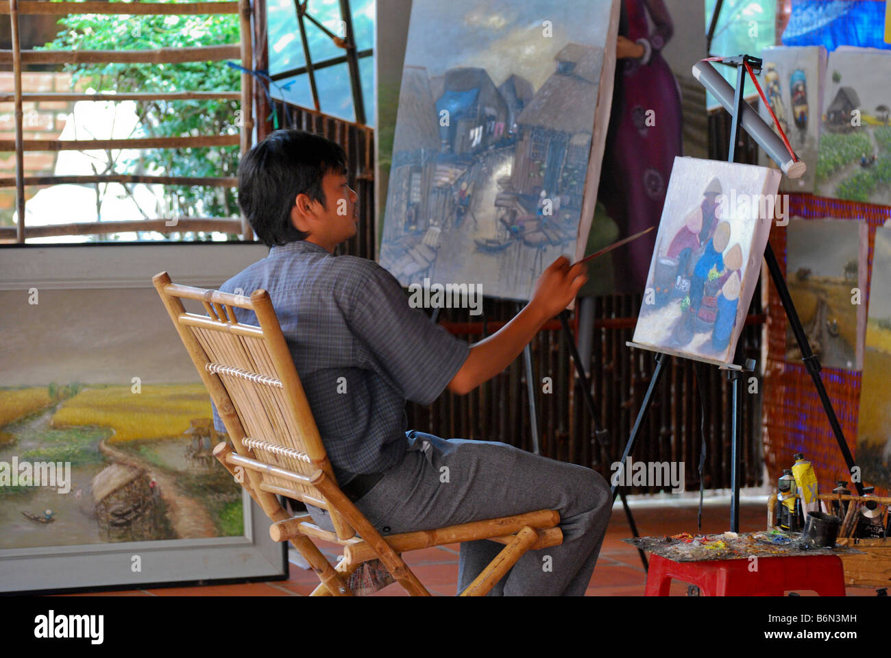 Peintre vietnamien au travail dans la galerie, ville de Cai Be, Delta du Mekong, Vietnam Banque D'Images