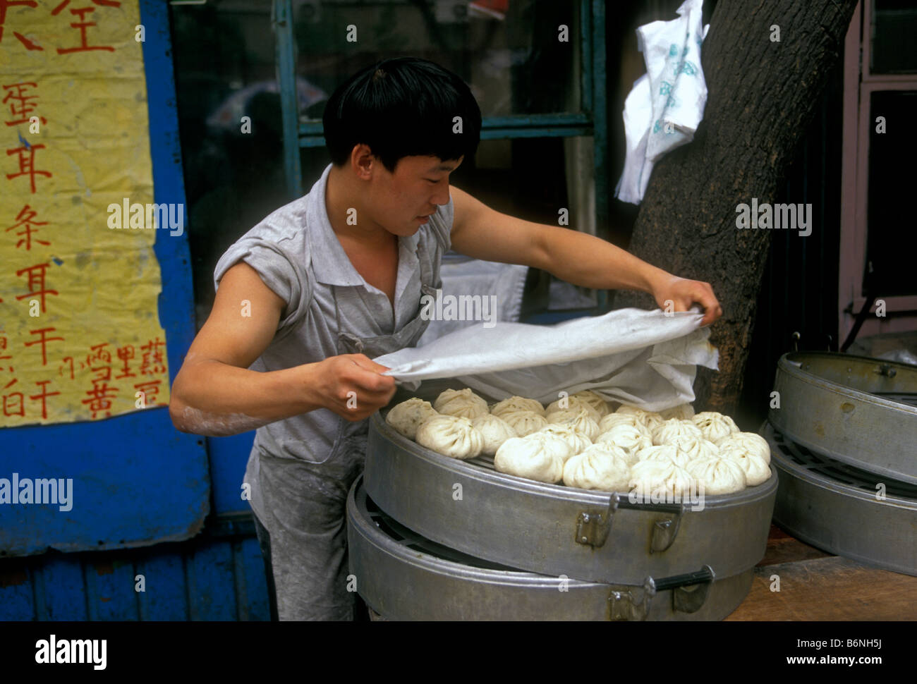 L'homme chinois, le porc bun bun porc, du vendeur le vendeur, la vente de porc cuit à la vapeur, des petits pains, brioches de porc marché 1A Longxiang Road, Beijing, la municipalité de Beijing, China, Asia Banque D'Images