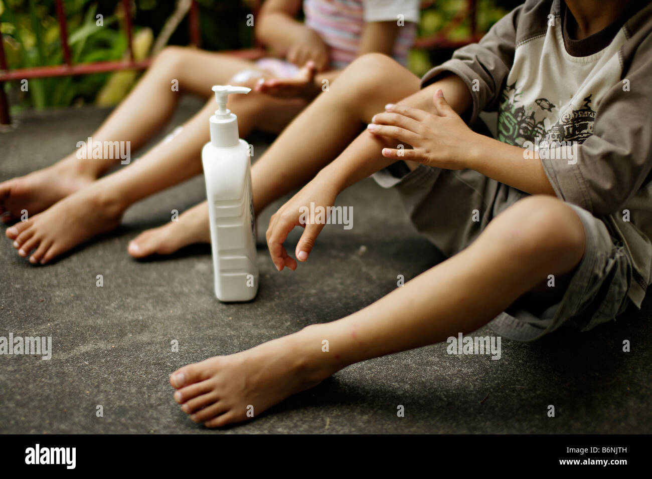 Appliquer la crème solaire enfants fille garçon de 6 ans 5 ans Banque D'Images