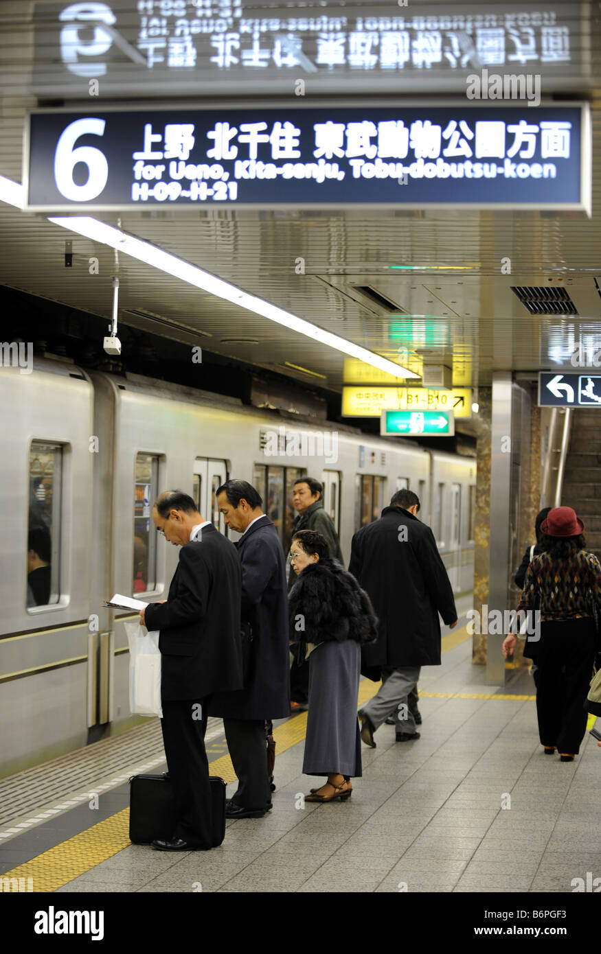 Les passagers sont à la plate-forme de la station de métro de Tokyo comme un train arrive Banque D'Images