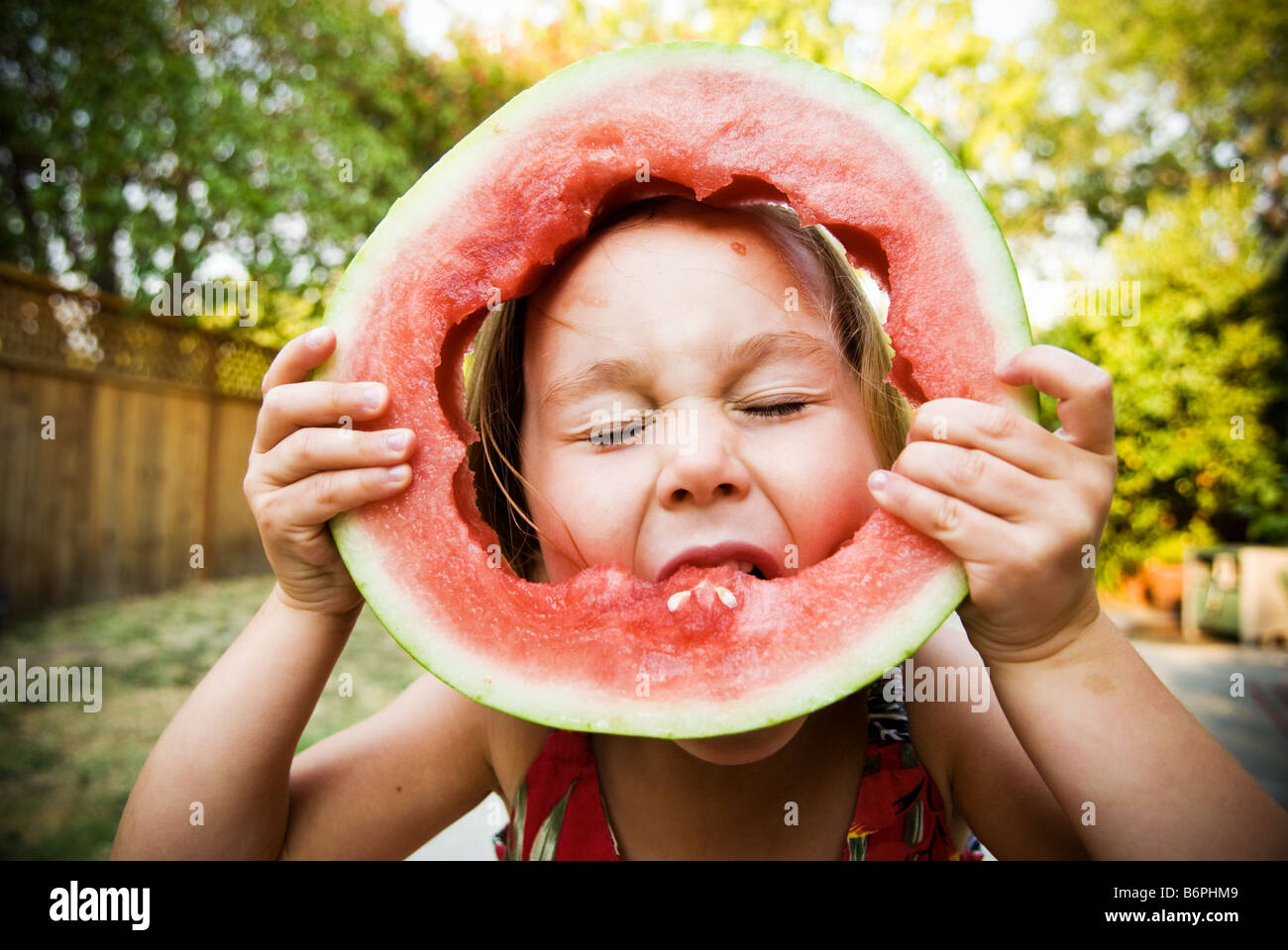 Une jeune fille (3-5) avec bonheur de manger une tranche de pastèque. Banque D'Images
