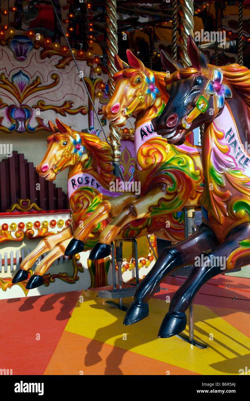 Le galop merry-go-round chevaux avec des rubans de couleur au soleil Banque D'Images