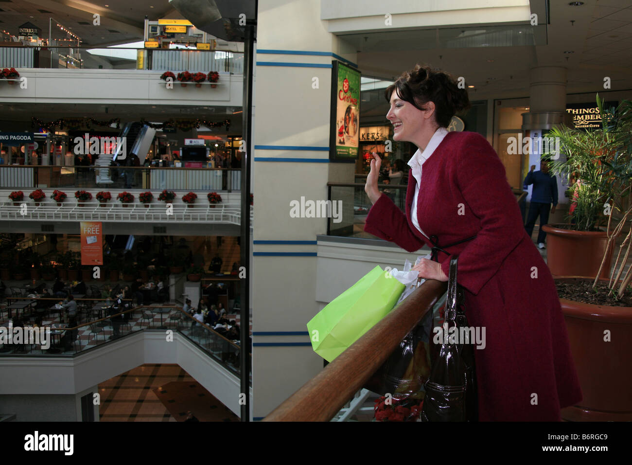 Les vagues de femme à un ami tout en faisant du shopping dans un centre commercial de New York. Banque D'Images