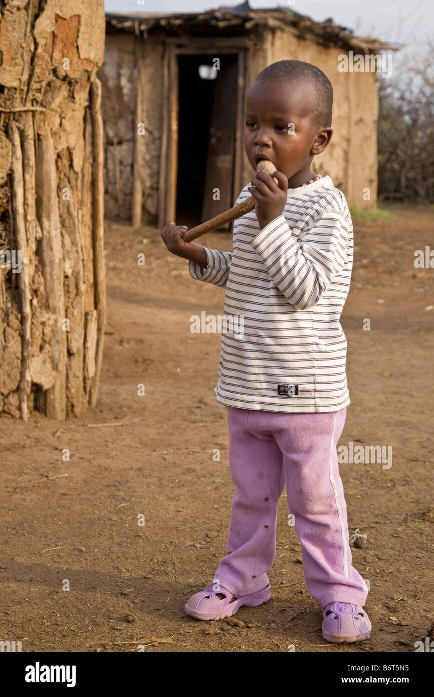 Garçon dans village près de parc Masai Mara Kenya Afrique Banque D'Images