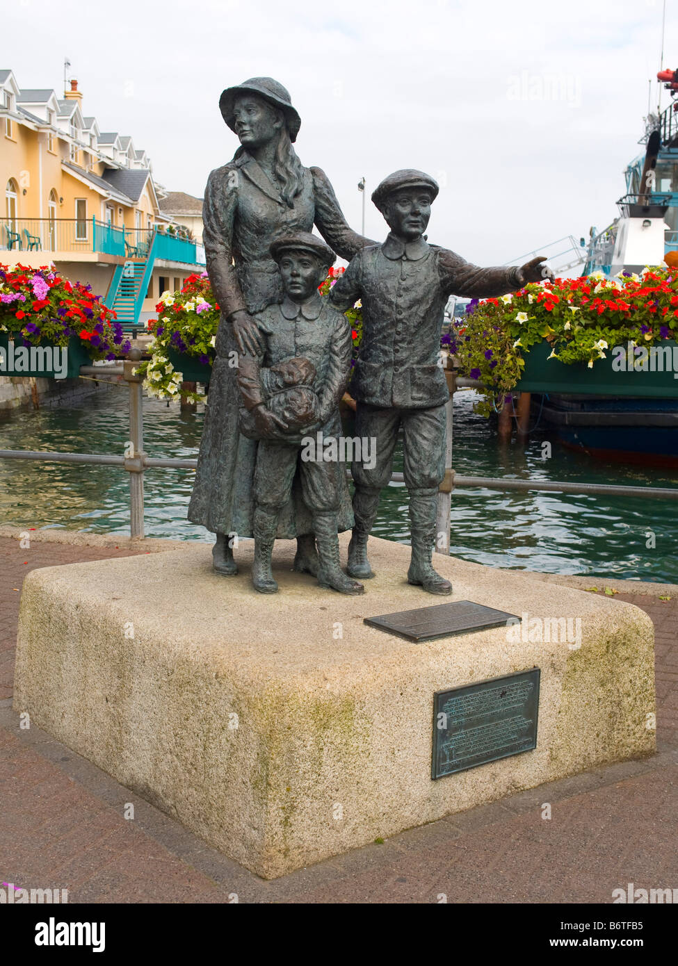 Statue d'Annie Moore et ses 2 frères sur l'eau à port de Cobh, dans le comté de Cork, en République d'Irlande. Banque D'Images