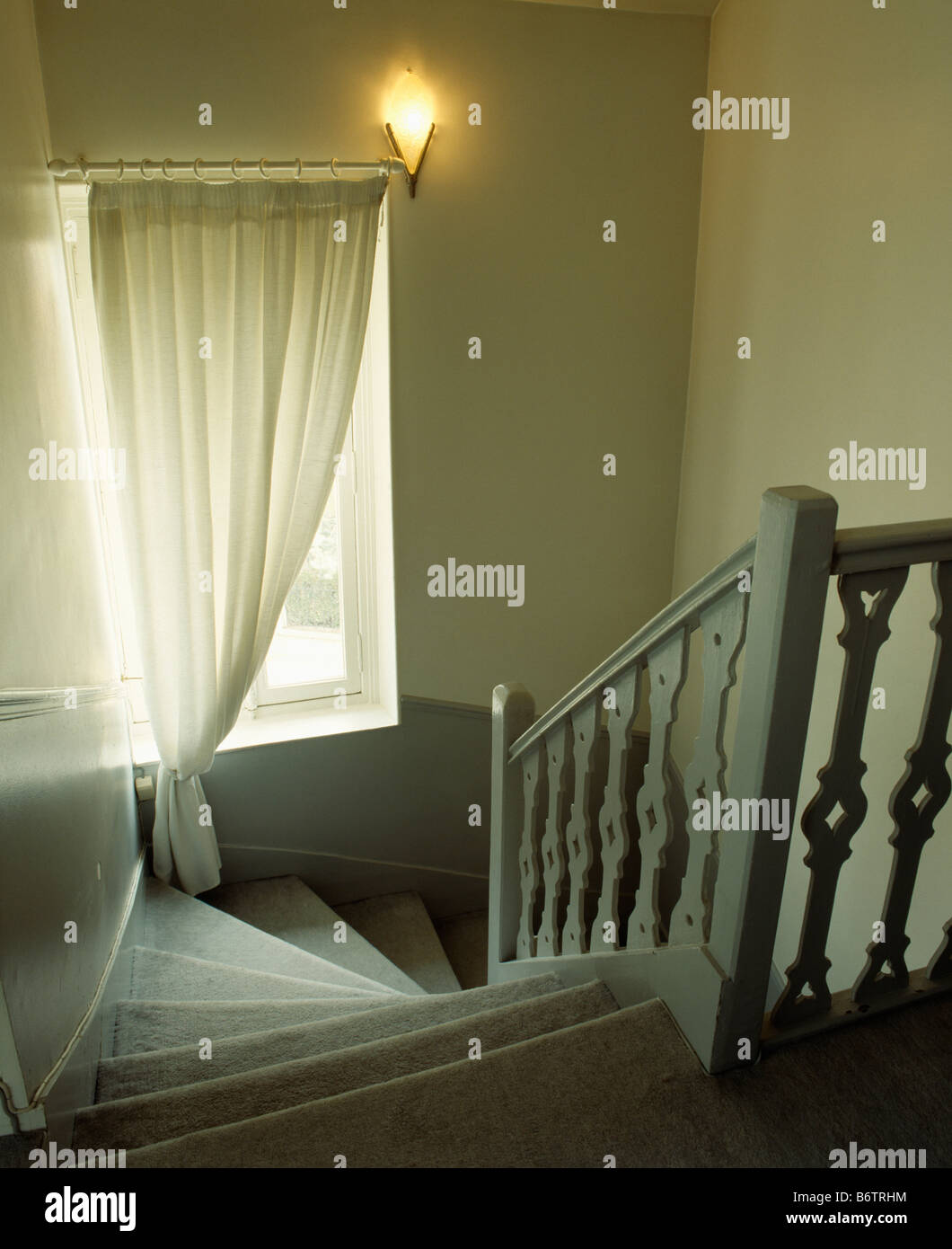 Regardant vers le bas escalier avec balustrade gris pâle à la fenêtre avec  rideau voile crème Photo Stock - Alamy