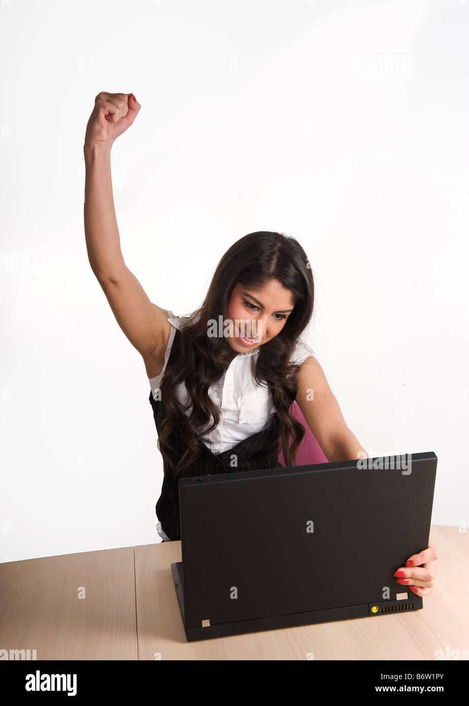 Belle jeune fille travaillant sur ordinateur portable montrant le dévouement et la réussite Banque D'Images