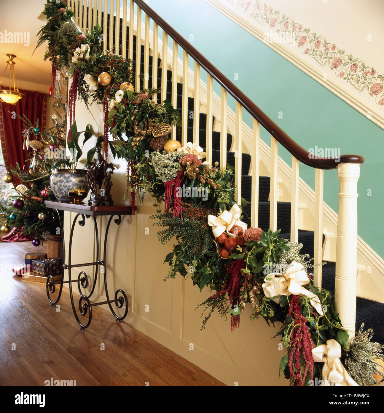 Comment Décorer Une Rampe D Escalier Pour Noel Guirlande de Noël feuillage frais et des rubans rouges sur les rampes d' escalier dans un hall avec dado turquoise Photo Stock - Alamy