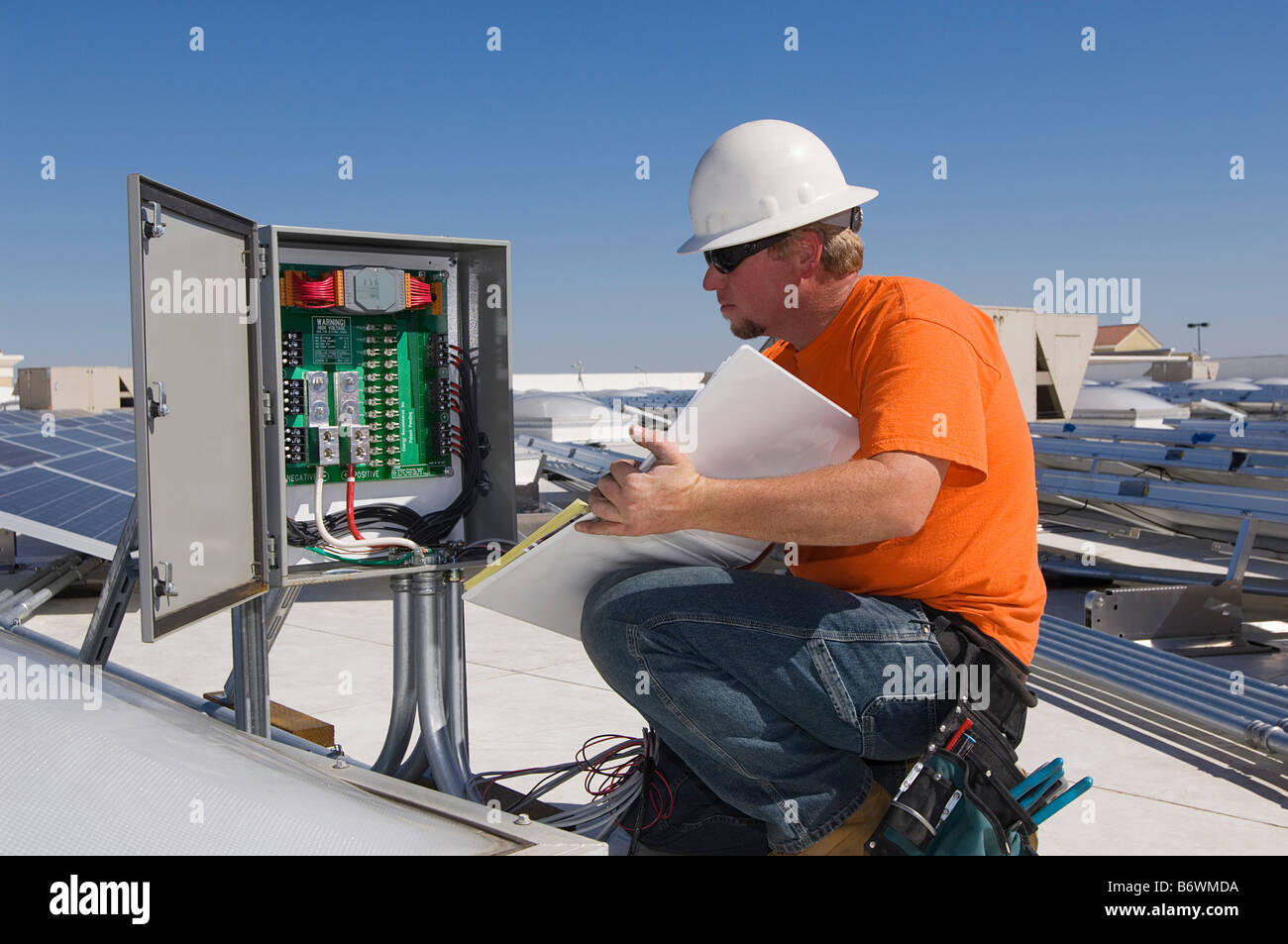 Ingénieur travaillant sur la boîte électrique à l'installation solaire Banque D'Images