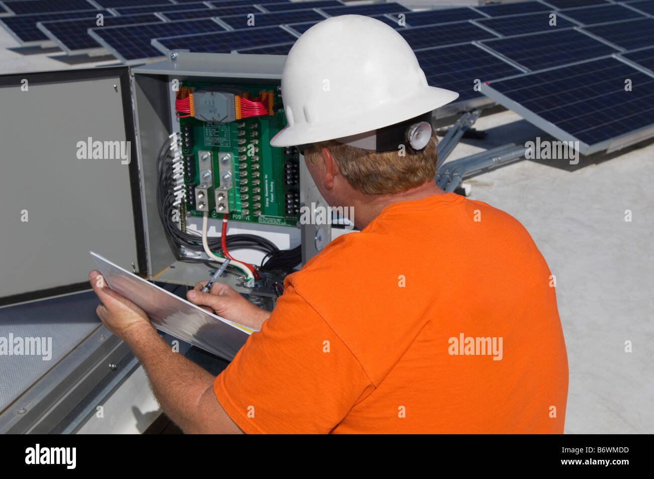 Ingénieur travaillant sur la boîte électrique à l'installation solaire Banque D'Images