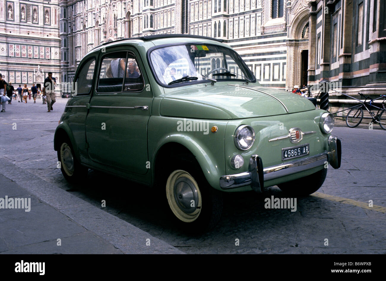 Un vert olive 1957 Fiat 500 Nuova avec un toit escamotable et porte battante arrière-stationné dans la Piazza del Duomo, Florence, Italie Banque D'Images