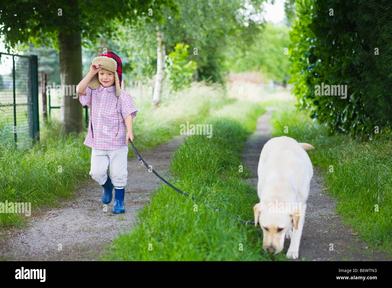 Un garçon promenait son chien Banque D'Images