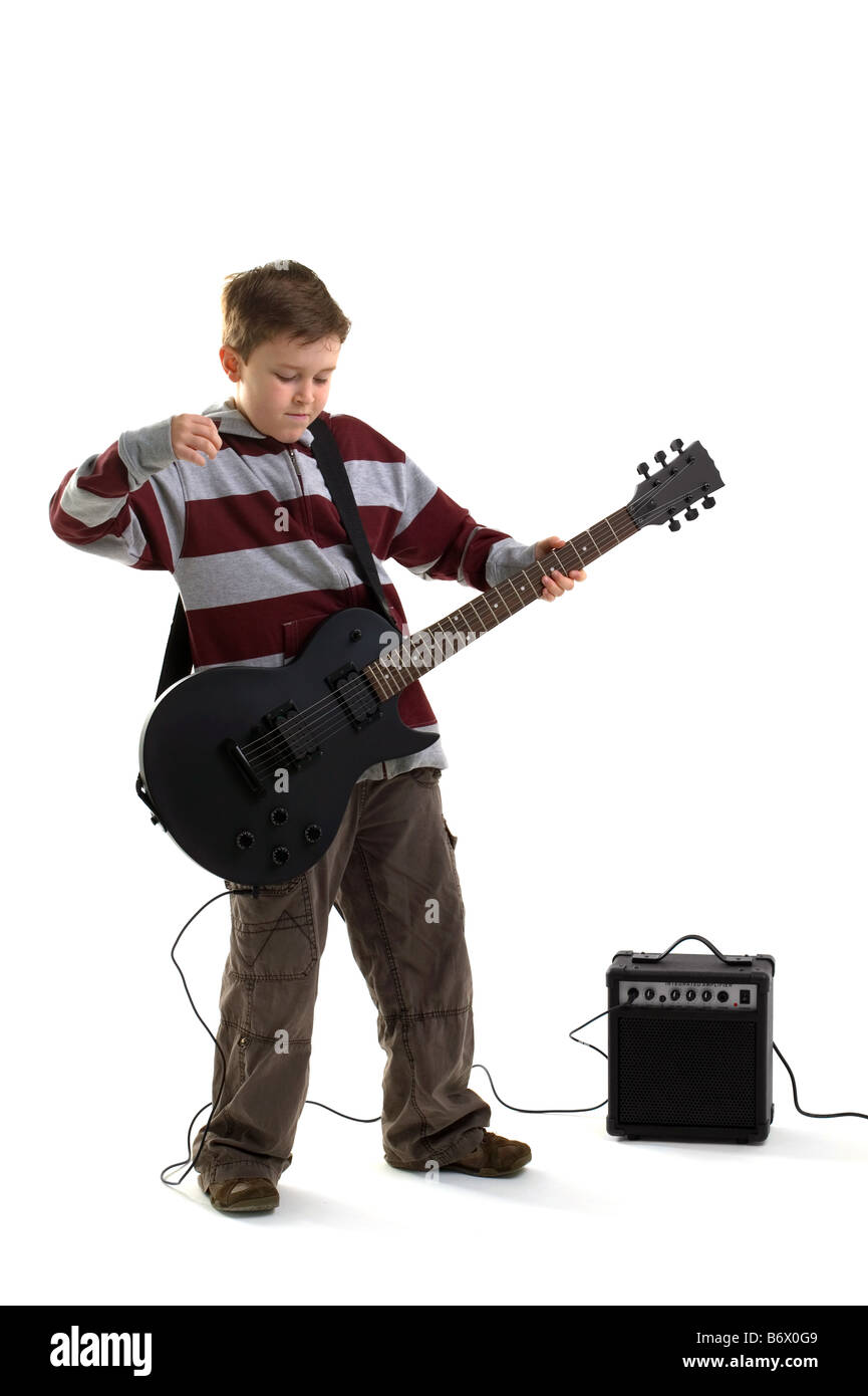 Un garçon sur le point de frapper un accord sur une guitare électrique noir mat avec amplificateur isolé sur fond blanc Banque D'Images