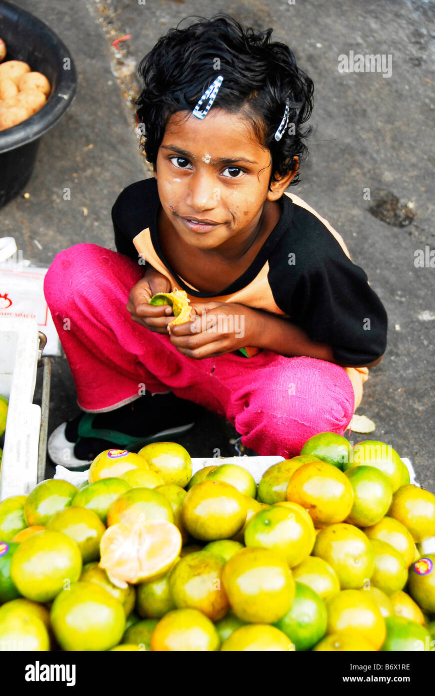 Bermese kid avec Tanaka sur son visage,des oranges à Maesot Tak,marché,Thaïlande. Du nord Banque D'Images