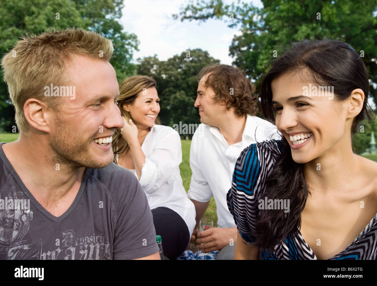 Les hommes et les femmes assis dans un parc Banque D'Images