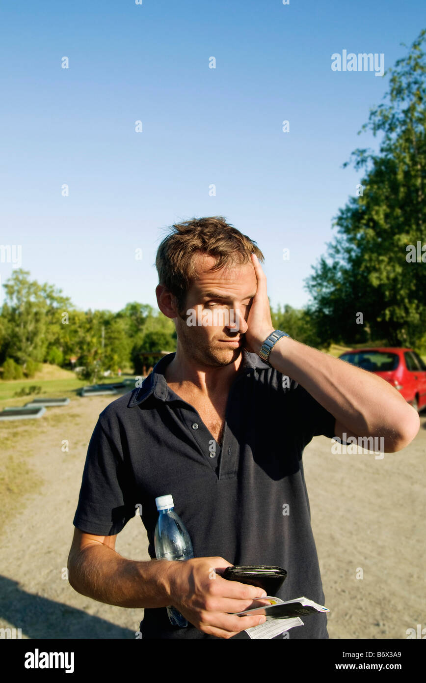 Homme fatigué sur place parking Banque D'Images