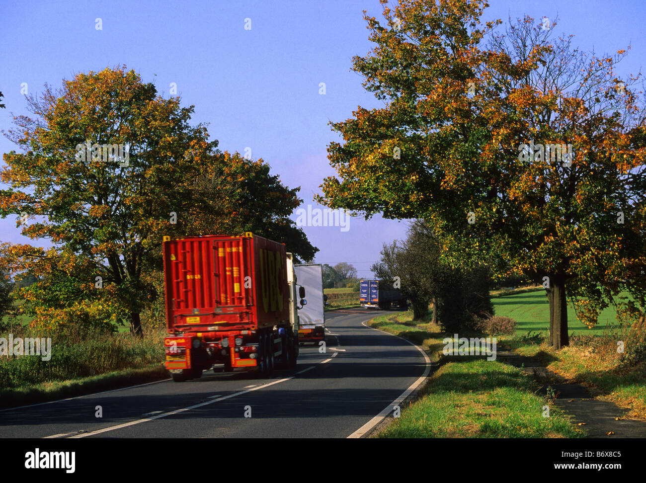 Lorrys voyageant sur la route à travers les arbres aux couleurs de l'automne près de Leeds Yorkshire UK Banque D'Images