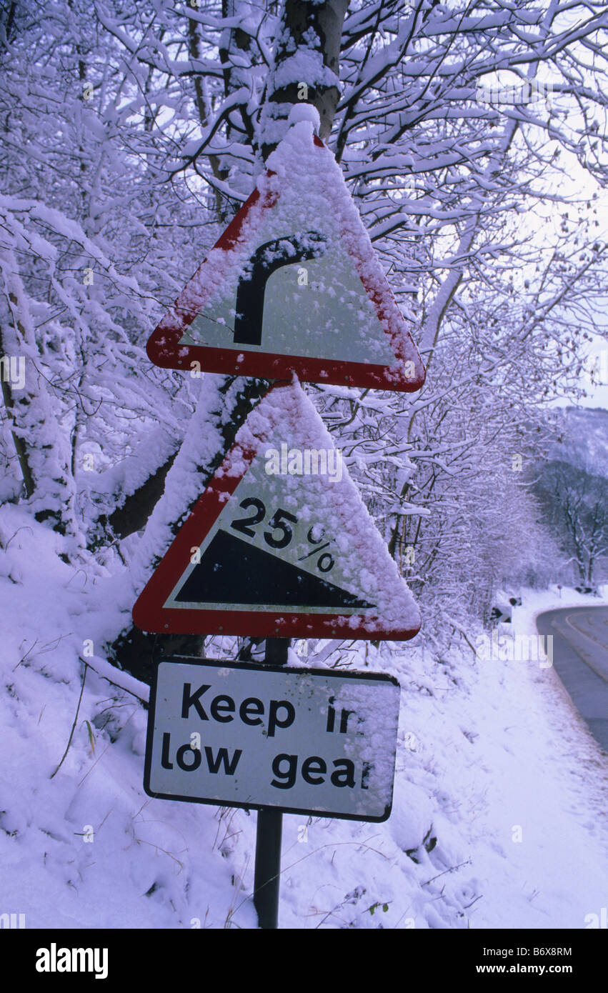Signes précurseurs de virage et colline couverte de neige de l'hiver à Sutton Bank près de Thirsk Yorkshire Moors UK Banque D'Images