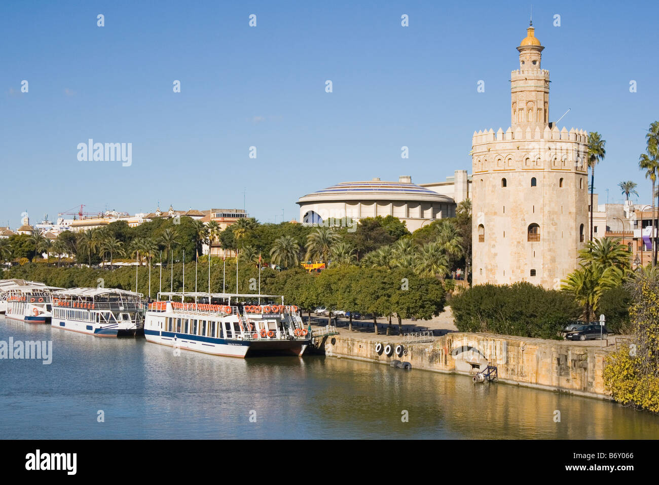 Séville Espagne La Torre del Oro, avec des bateaux d'excursion en face sur le fleuve Guadalquivir Banque D'Images