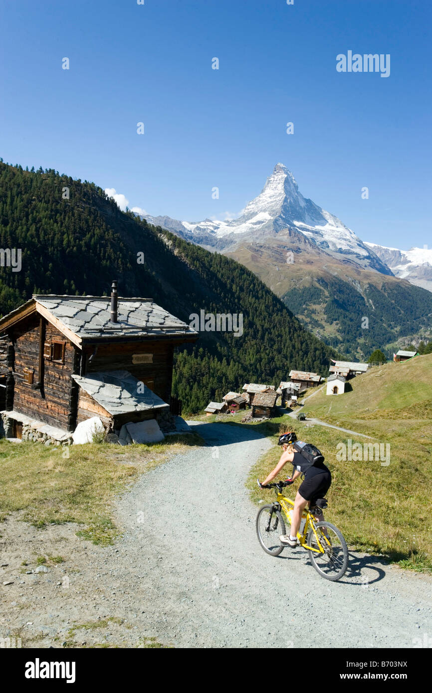 Mountainbiker femelle arrivant le village de montagne de Findeln, Matterhorn (4478 m) en arrière-plan, Zermatt, Valais, Suisse Banque D'Images