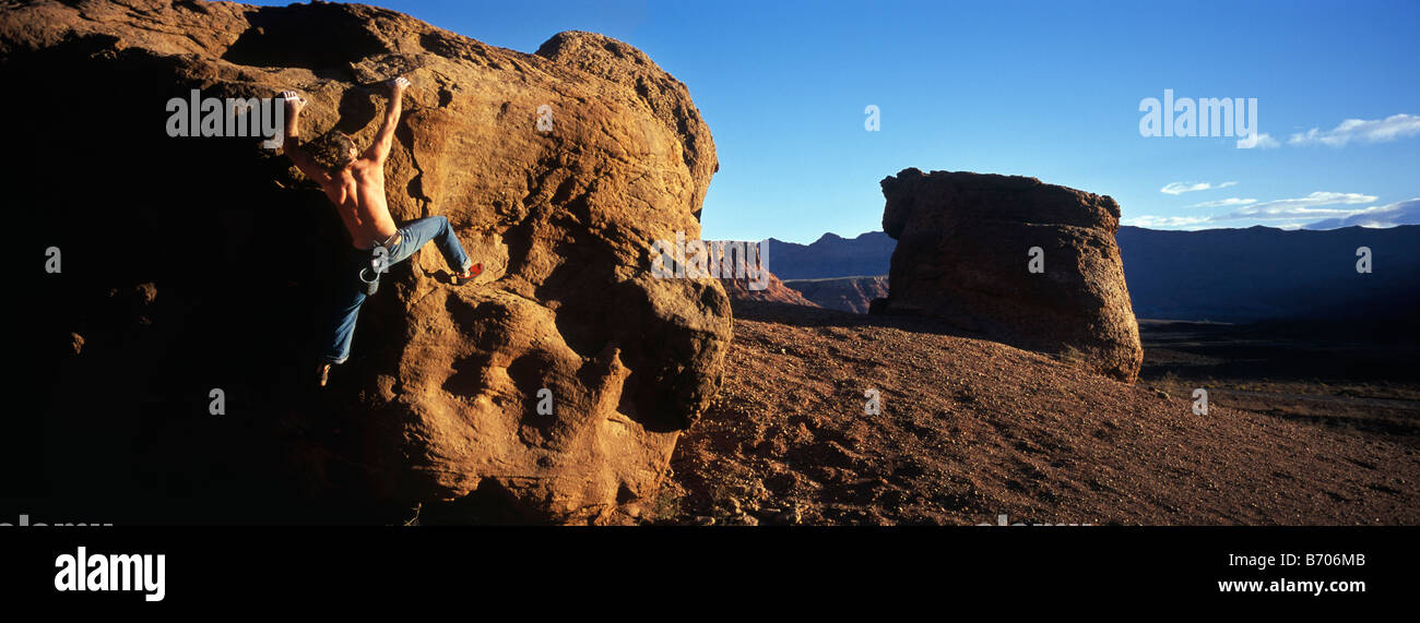 Un jeune homme grimpe rock un rocher dans le désert près de Marble Canyon, Arizona. Banque D'Images