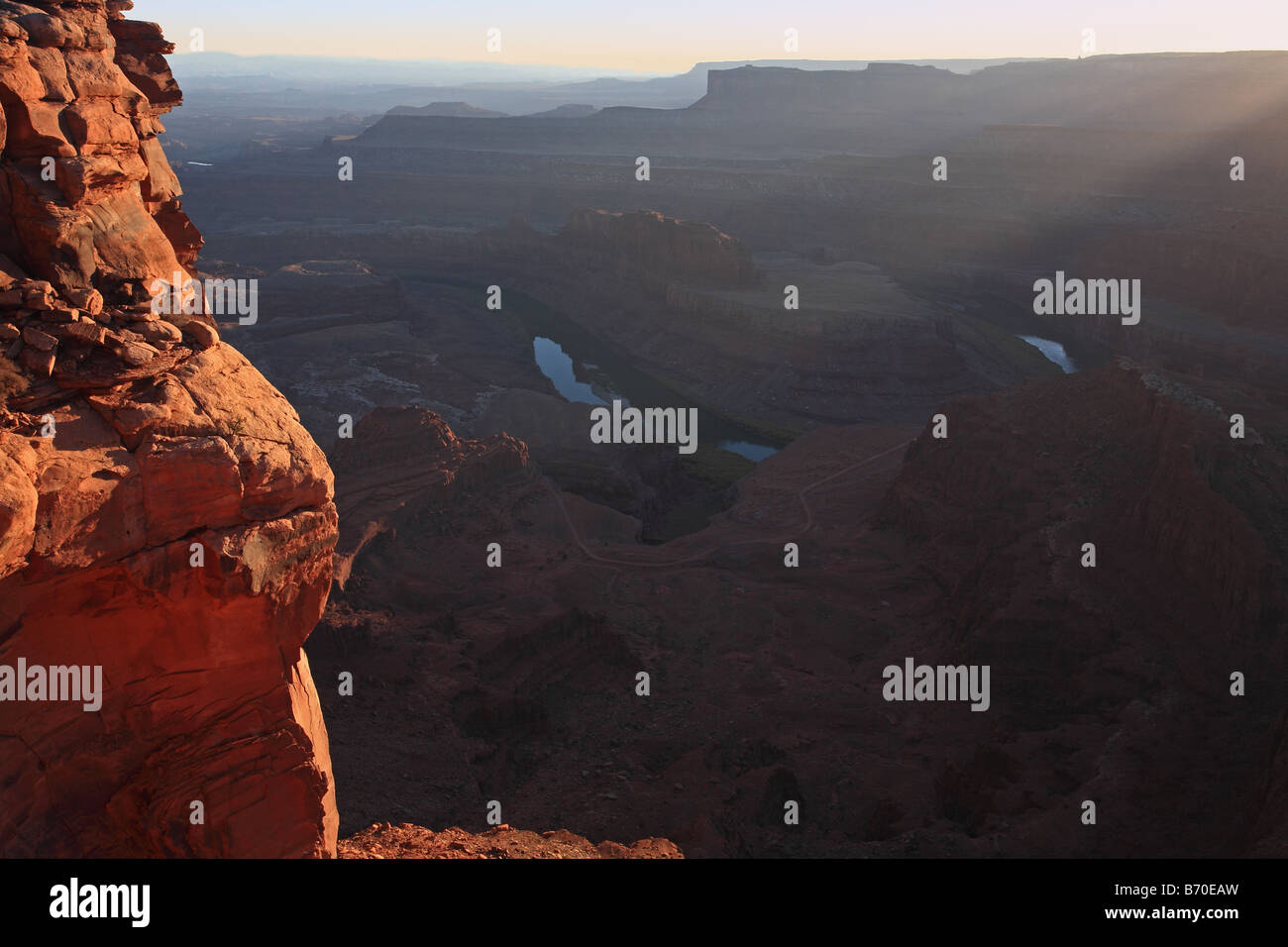 Falaise rougeoyante et une rivière au coucher du soleil. Banque D'Images