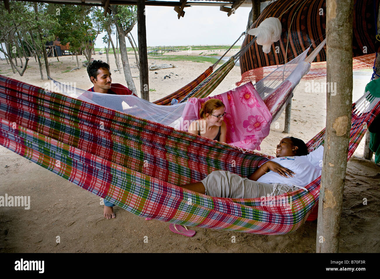 Le Suriname, Matapica Parc National. Les touristes se détendre dans un hamac sur la plage. Banque D'Images