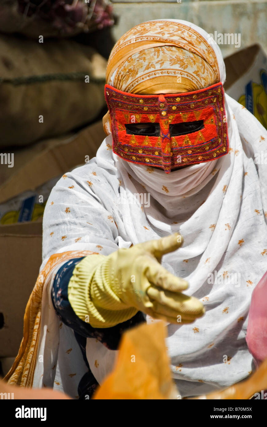 Femme avec burqa vendre des marchandises dans un marché de rue Bandar Abbas Iran e Banque D'Images