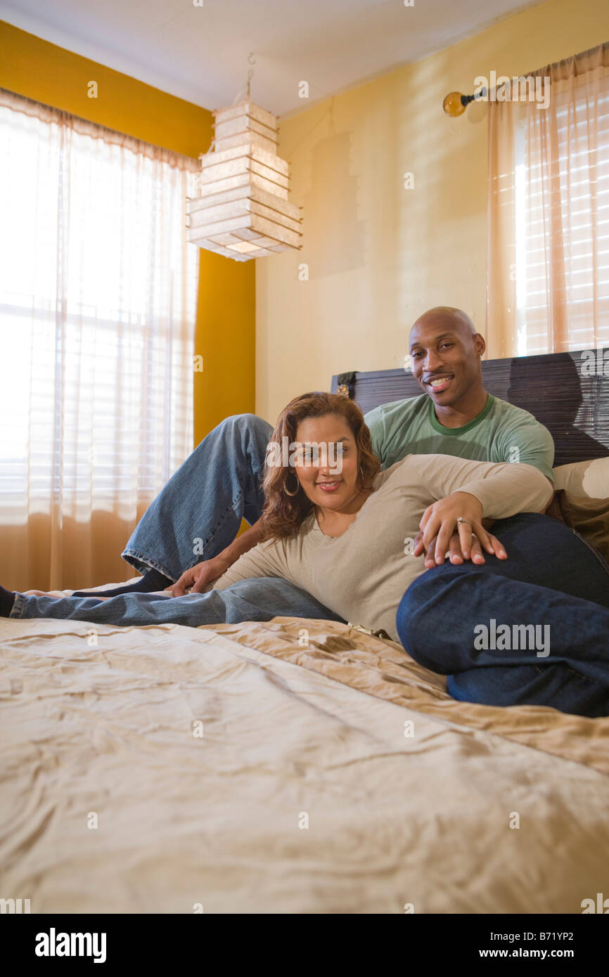 Heureux couple interracial hispanique afro-américaines on bed Banque D'Images