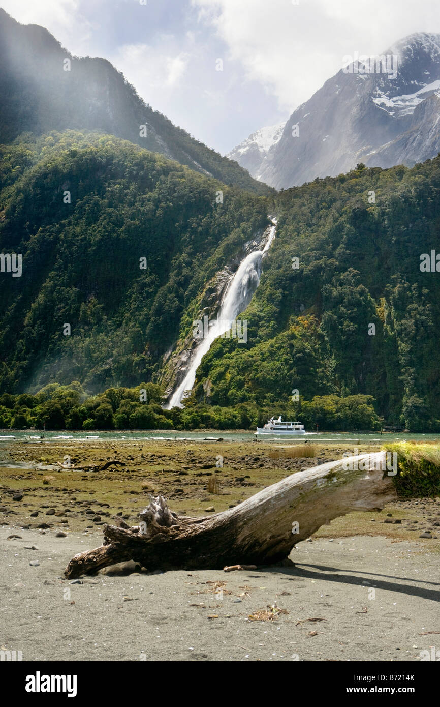 Nouvelle Zélande, île du Sud, le Parc National de Fiordland, Milford Sound. Bowen Falls et bateau de tourisme. Banque D'Images