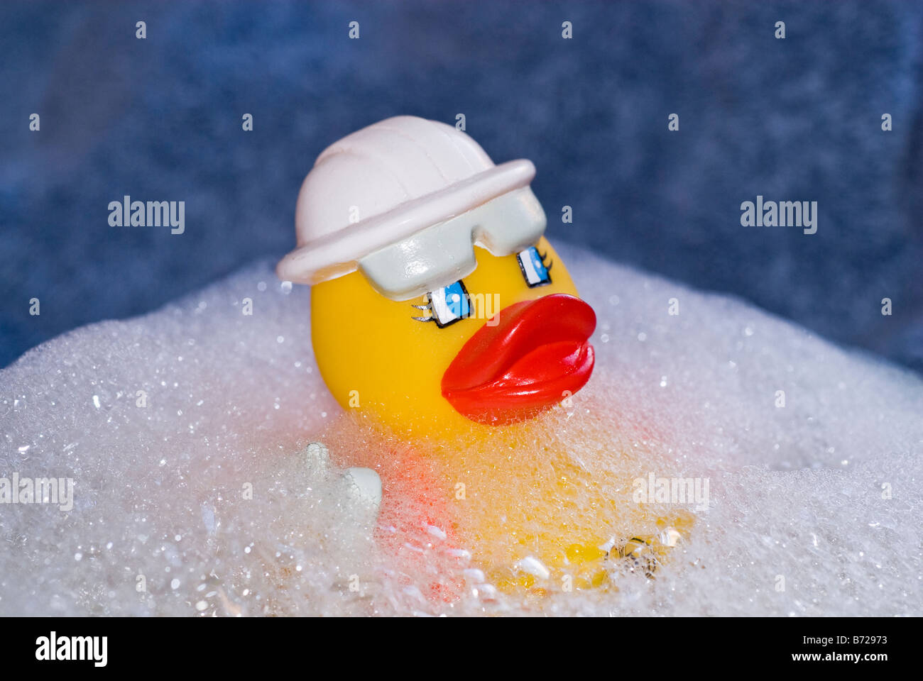 Canard en caoutchouc flottant dans un baquet d'eau du bain bouillonnant et savonneux. Stock Photography par cahyman. Banque D'Images