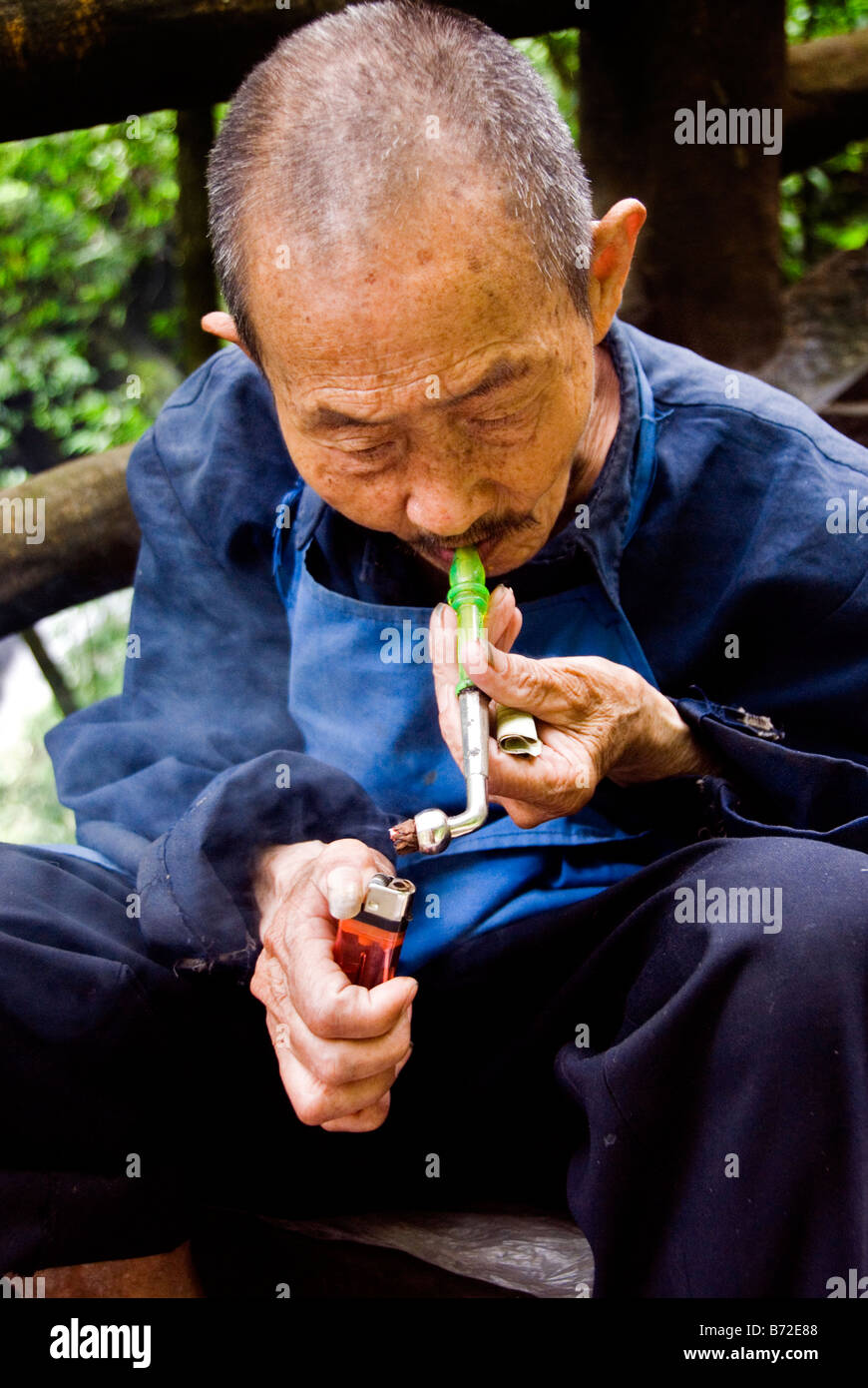 Chinesse vieux homme fumant une pipe Emei Shan Chine Sichuan Banque D'Images