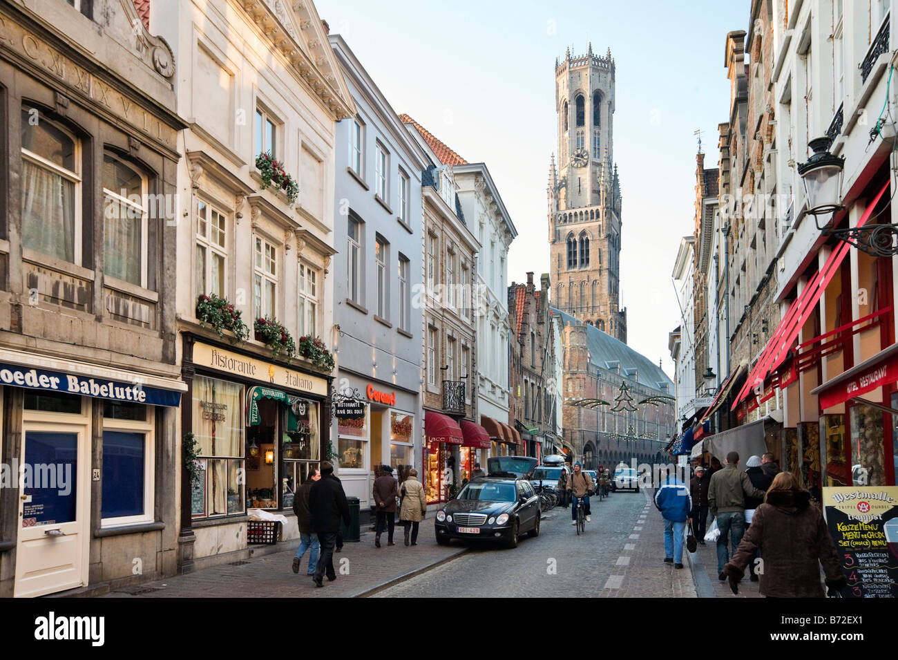 Rue commerçante dans le centre de la vieille ville à l'époque de Noël avec la tour du beffroi derrière, Bruges, Belgique Banque D'Images