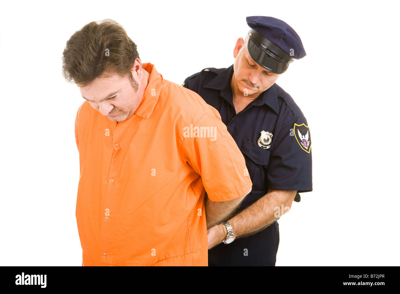 Prisonnier en orange jump suit être menotté par la police officer isolated on white Banque D'Images