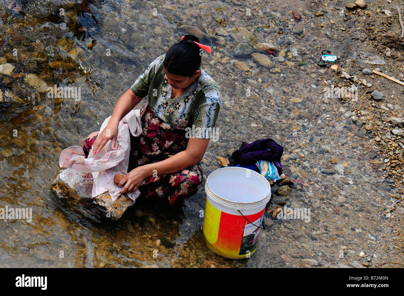 Femme de réfugiés est laver les vêtements dans la rivière près du camp de réfugiés de Maela,Tak,le nord de la Thaïlande Banque D'Images