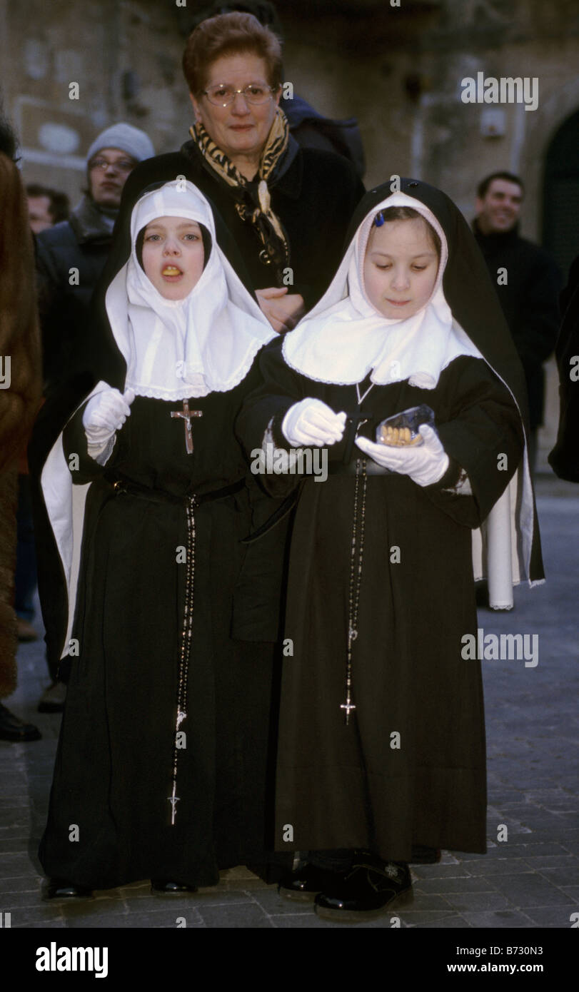 Les filles habillés en nonnes à Settimana Santa Semaine Sainte procession le dimanche des Rameaux nuit à Enna Sicile Italie Banque D'Images