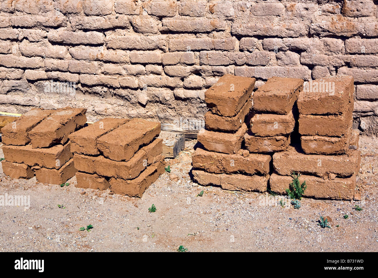 Image de briques adobe traditionnelles de séchage et empilés contre un mur de briques d'adobe dans le soleil Banque D'Images