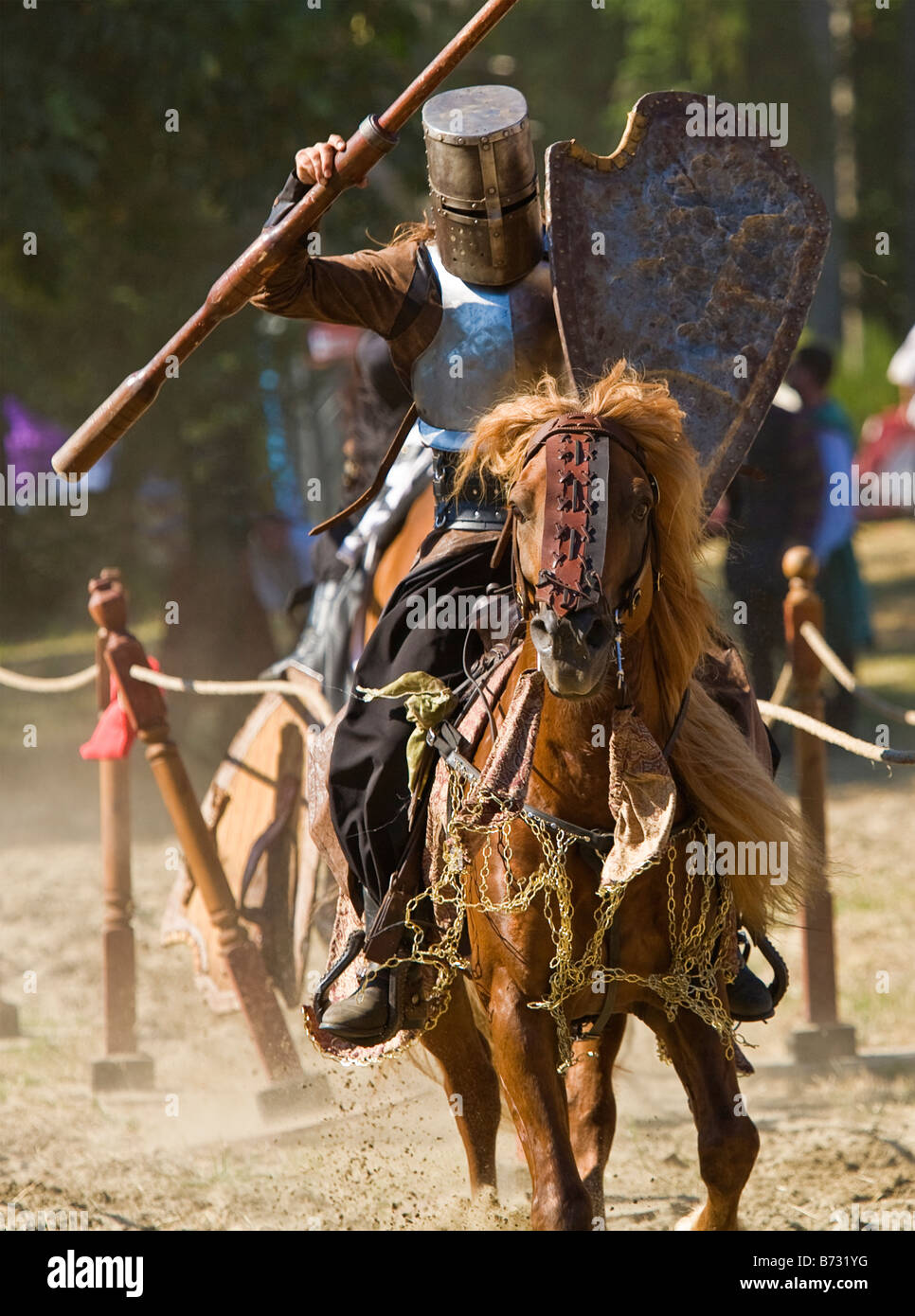 Image d'un homme vêtu de vêtements de style médiéval et d'armures à cheval et portant une lance dans un tournoi de joutes Banque D'Images