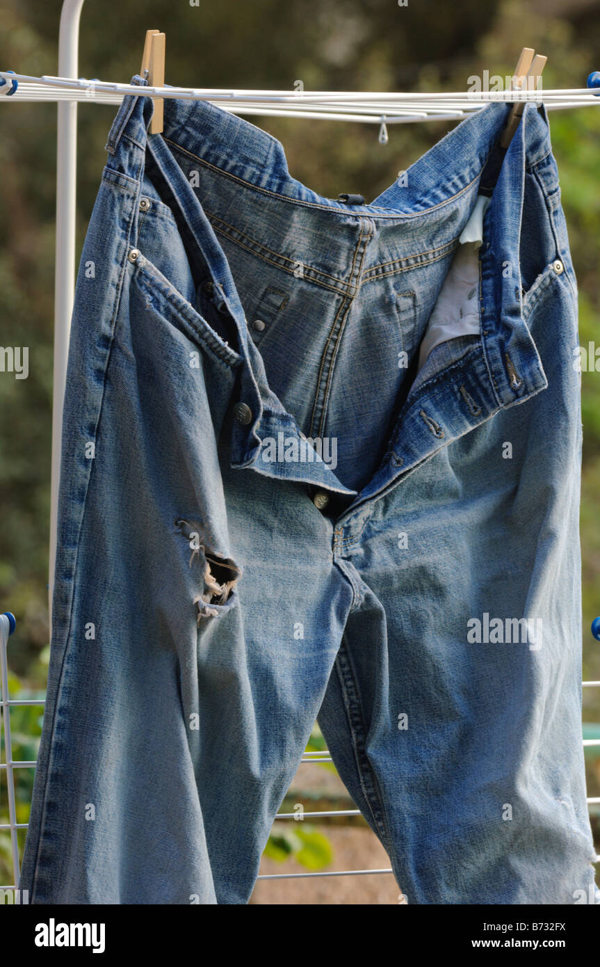 Vieux, déchirés, usés jeans pantalons mis à sécher Banque D'Images