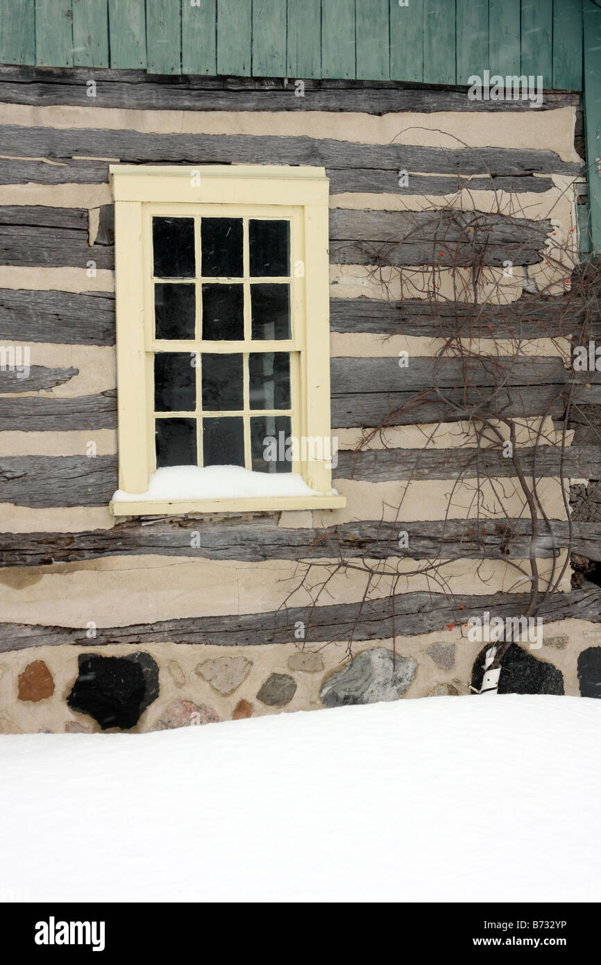Un pays log cabin et châssis de fenêtre jaune dans le Wisconsin pendant l'hiver Banque D'Images