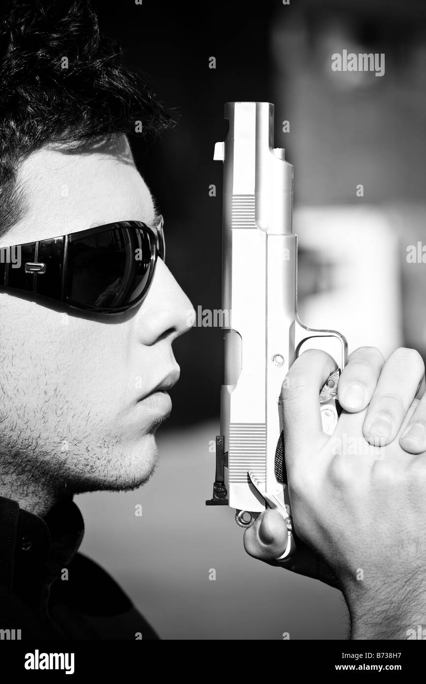 Modèle masculin avec une arme d'un agent secret de la scène Banque D'Images