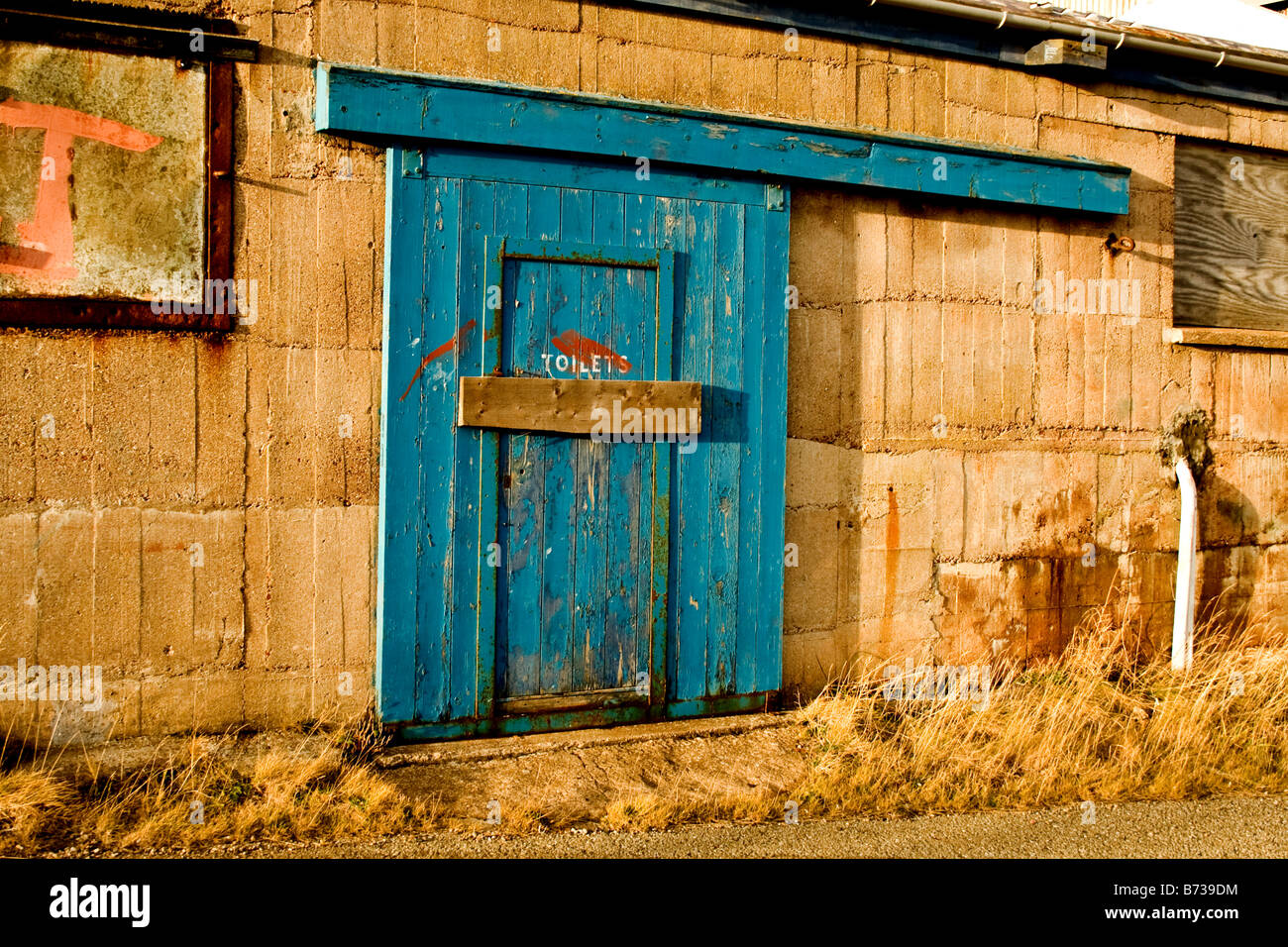 Ancien bloc toilettes avec porte en bois bleu et barre en bois à travers la porte de Buckie, Ecosse Banque D'Images Ancien bloc toilettes avec porte en bois bleu et barre en bois à travers la porte de Buckie, Ecosse Banque D'Images