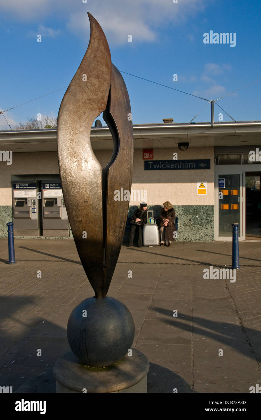 Une sculpture à l'extérieur de la gare de Twickenham avec deux femmes assises sur un banc et de parler à l'arrière-plan, London, UK Banque D'Images