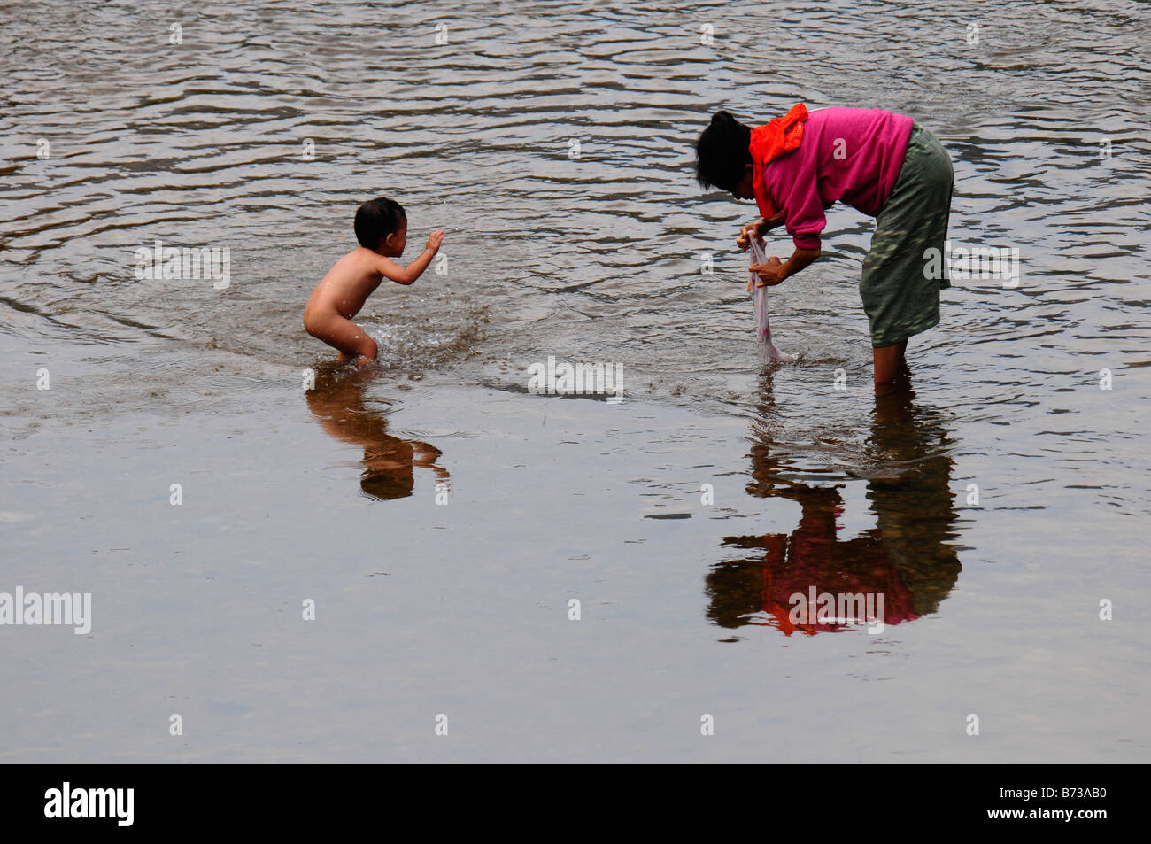 Petit enfant de réfugié est aimer marcher alors que la mère est la lessive dans la rivière près du camp de réfugiés de Maela,Tak,le nord de la Thaïlande Banque D'Images