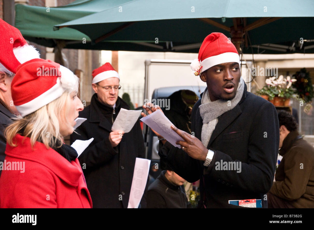 Carol singers à l'extérieur de l'église St Mary Le Bow, Cheapside, Londres, UK Banque D'Images