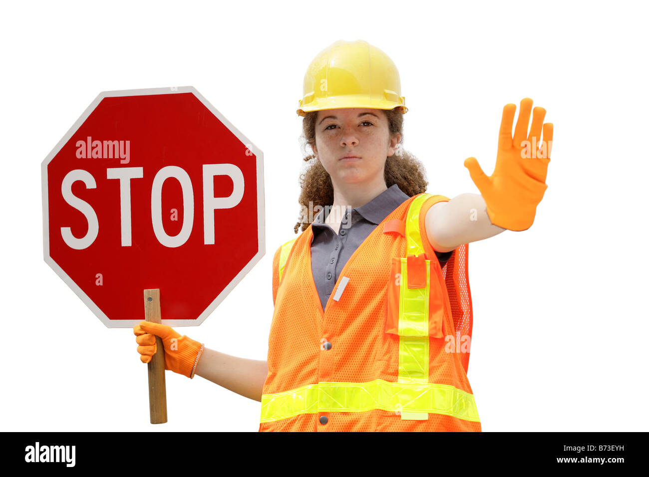 Une femelle construction worker wearing gilet tenant un panneau d'arrêt isolé Banque D'Images