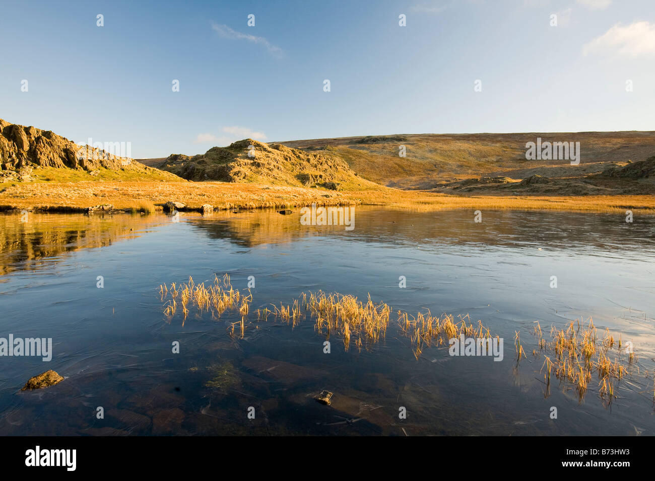 Un chef Dale sur tarn gelé dans le district du lac au-dessus de la vallée de Newlands UK Banque D'Images