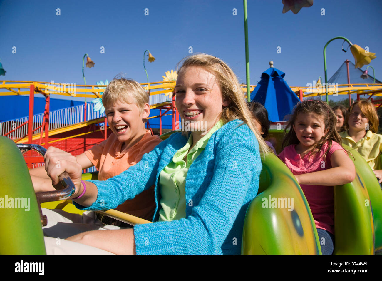 Les jeunes passagers de montagnes russes dans un parc d'amusement Banque D'Images