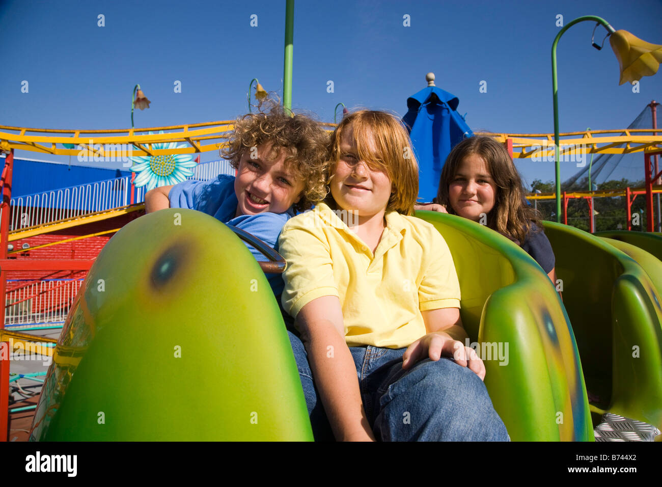 Les jeunes passagers de montagnes russes dans un parc d'amusement Banque D'Images